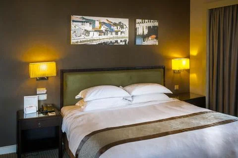 Beautiful interior decoration of a bedroom with bed, pillows, side tables and Stock Photos