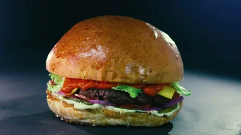 Beautiful juicy Burger in the smoke on a black background. Stock Footage