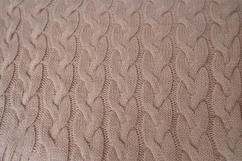 Beautiful knitted braid pattern of light brown wool yarn, knitted texture, co Stock Photos