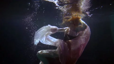 Beautiful lady is diving into depth of ocean, magical and dreamy underwater shot Video stock 167279970