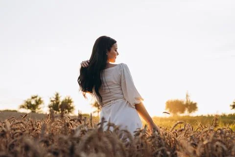 The beautiful lady is looking at something while holding wheat in her right.. Foto stock