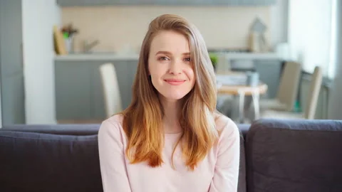 Beautiful lady looking t camera and smiling at home Stock Footage 154734611