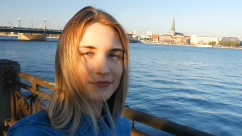Beautiful lady making a selfie in front of a Riga city panorama at sunset 動画素材 101239750