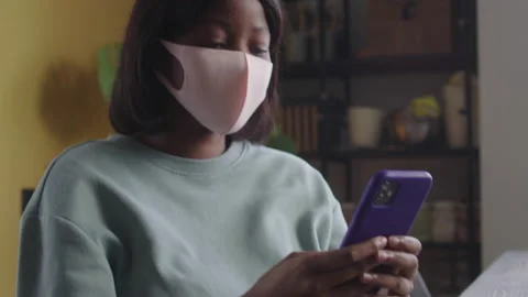 A beautiful lady in a protective mask is looking something on the phone Stock Footage 170462469