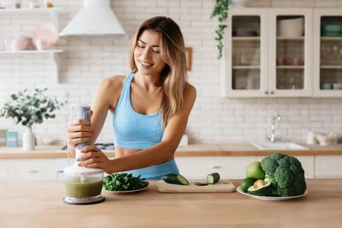 Beautiful lady smiling while cooking a smoothie Stock Photos