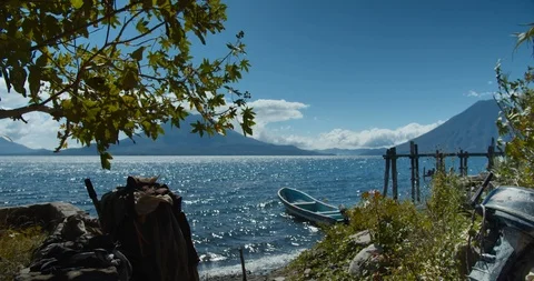 Beautiful Lake Atitlan view with distant volcano, deserted boat in water and 動画素材 123097812