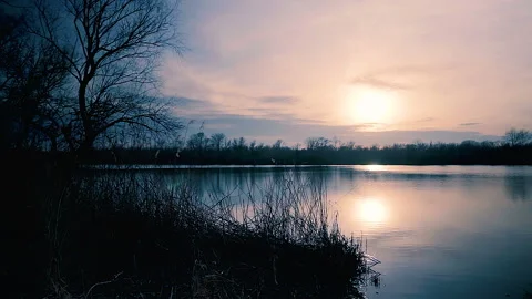 Beautiful lake in light of setting sun. Panning shot of sunset on river. Stock Footage 87265742