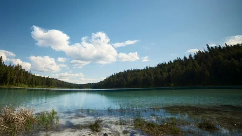 Beautiful lake with panning left time lapse as clouds move across sky Stock Footage 128408072