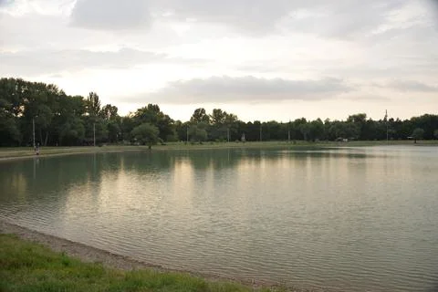 Beautiful lake at sunset, the rays of the sun paint the water and small waves in Stock Photos