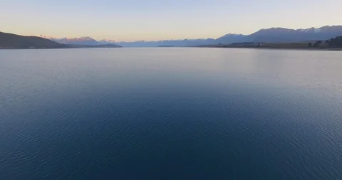 Beautiful Lake Tekapo with mountain range in background at dusk Stock Footage 119165247