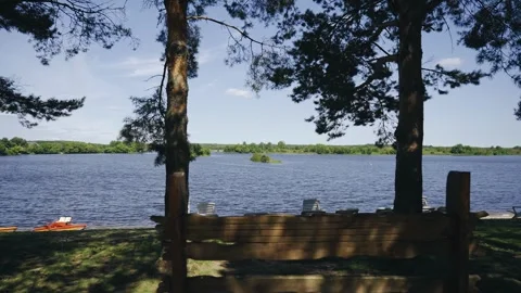 A beautiful lakeside and a small bench where you can sit and relax Stock Footage 342667773