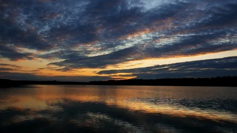 Beautiful landscape of dramatic clouds and sunset over wide lake Stock Footage 116604134