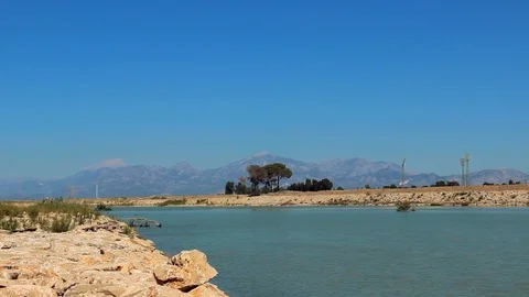 Beautiful landscape with flowing river, small trees and mountains Stock Footage