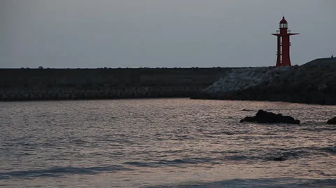 Beautiful landscape of sea waves by red lighthouse at sunset Stock Footage 59131744