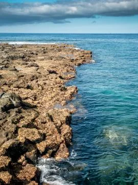 Beautiful landscape of sharp cliffs and rocks and calm ocean water Stock Photos