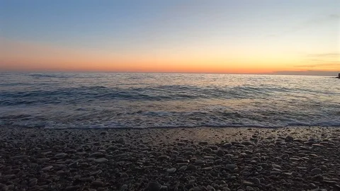Beautiful landscape of surging waves ashore in the rays of sunset Video stock 128373249