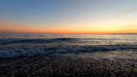 Beautiful landscape of surging waves ashore in the rays of sunset Video stock 128373260