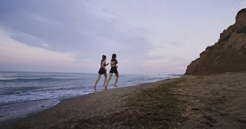 Beautiful landscape view on the beach two attractive ladies running together in Stock Footage 115200783