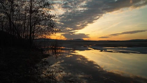 Beautiful landscape view of freshwater lake with melting ice at sunset. Stockbeeldmateriaal 337563243