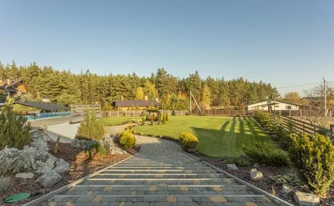Beautiful landscaping of personal plot. Beautiful lawn and various trees Stock Photos