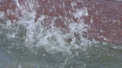 Beautiful large water drops fall on a stone in the city fountain on a sunny 스톡 동영상 148445882
