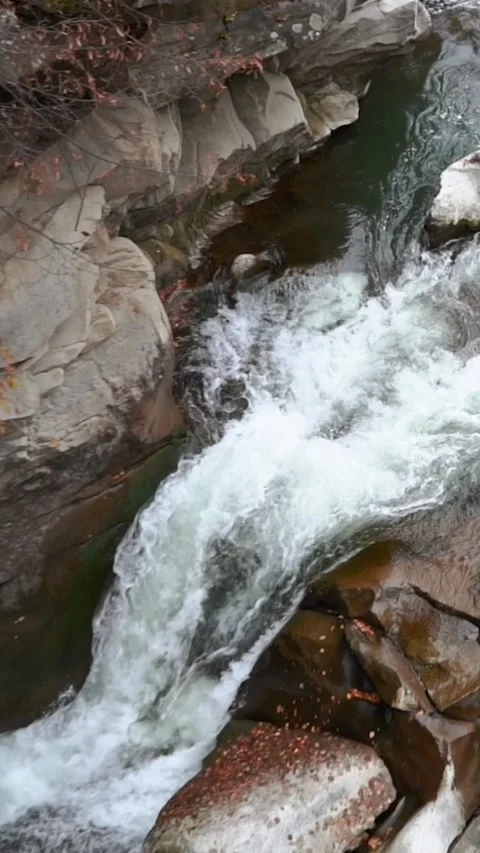 A beautiful large waterfall with cliffs high in the mountains. Travel and hike Stock Footage 325316194