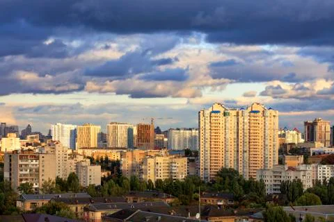 The beautiful light of the setting sun falls on the houses in the city landsc Stock Photos