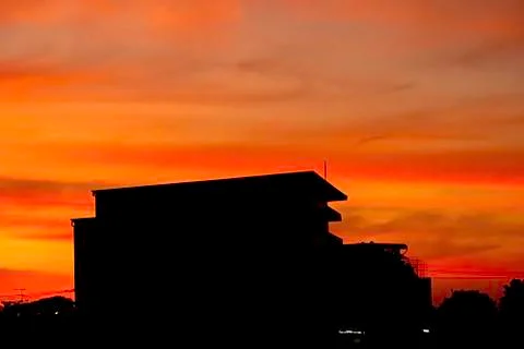 Beautiful light of Sunset with clouds in the sky reflection behind the buildi Stock Photos