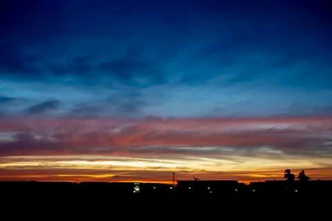 Beautiful light of Sunset with clouds in the sky reflection behind the buildi Stock Photos