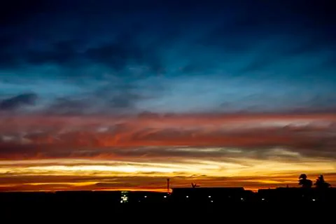 Beautiful light of Sunset with clouds in the sky reflection behind the buildi Stock Photos