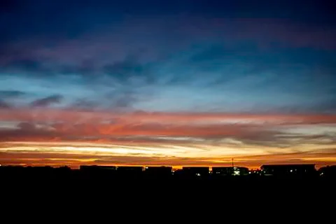 Beautiful light of Sunset with clouds in the sky reflection behind the buildi Stock Photos