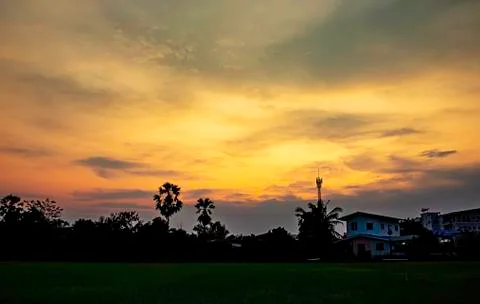 Beautiful light of Sunset with clouds in the sky reflection behind the buildi Stock Photos