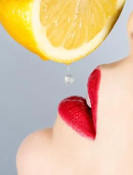 Beautiful lips and falling drop of lemon Stock Photos