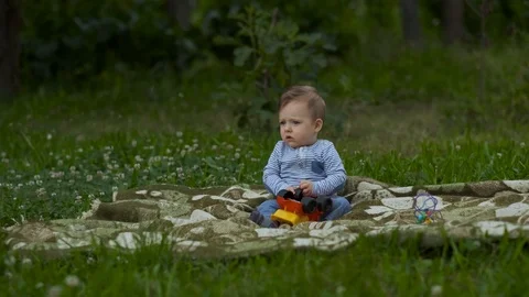 Beautiful Little Boy Is Playing Alone in Garden. Stock Footage 113683824