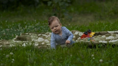 Beautiful Little Boy Is Playing Alone in Garden. Stock Footage 113684940