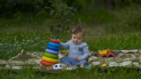 Beautiful Little Boy Is Playing Alone in Garden. Stock Footage 113687350