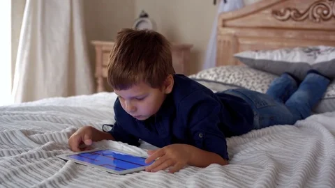 Beautiful little boy playing on the tablet computer games Stock Footage 71455804