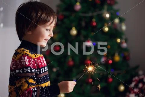 Beautiful Little child holding burning sparkler on New Year's Eve Stock Photos