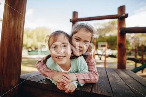 Beautiful little twin girls enjoying at playground Stock Photos