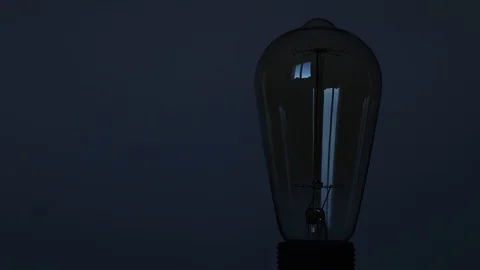 Beautiful loft Edison lamp with a warm yellow light illuminates Stock Footage 129640470