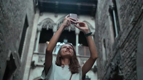 Beautiful long-haired brunette making photo under the arch. Young attractive Stock Footage 139350971