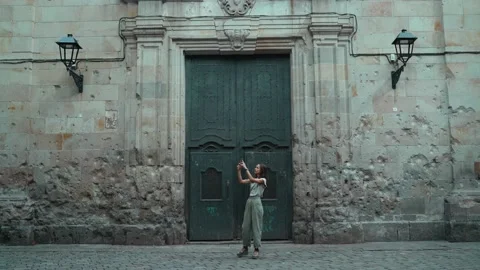 Beautiful long-haired brunette making photo in front of a large carved door Stock Footage 139351819