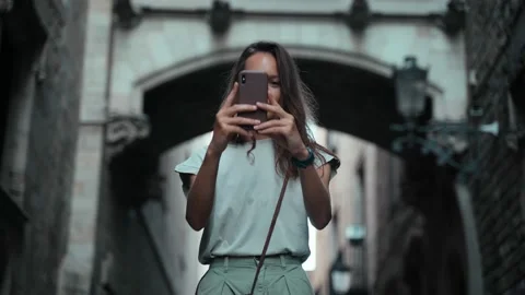 Beautiful long-haired brunette making photo under the arch. Young attractive Stock Footage 139441924