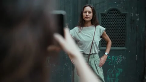 Beautiful long-haired brunette posing for a photo in front of a large carved Stock Footage 139350788