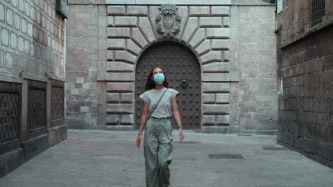 Beautiful long-haired brunette in protective mask walking around the beautiful Stock Footage 139351024