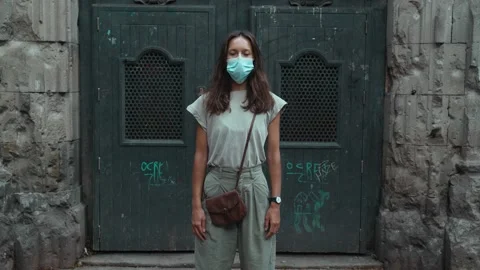 Beautiful long-haired brunette in protective mask. Young attractive woman is Stock Footage 139351402