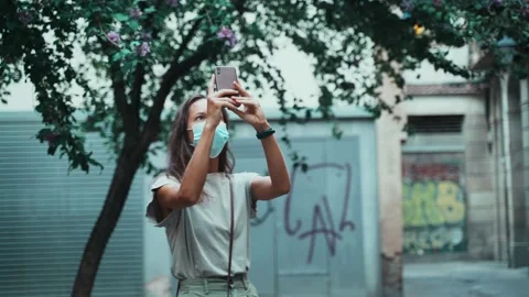 Beautiful long-haired brunette in protective mask makes selfie on the square Stock Footage 139441502