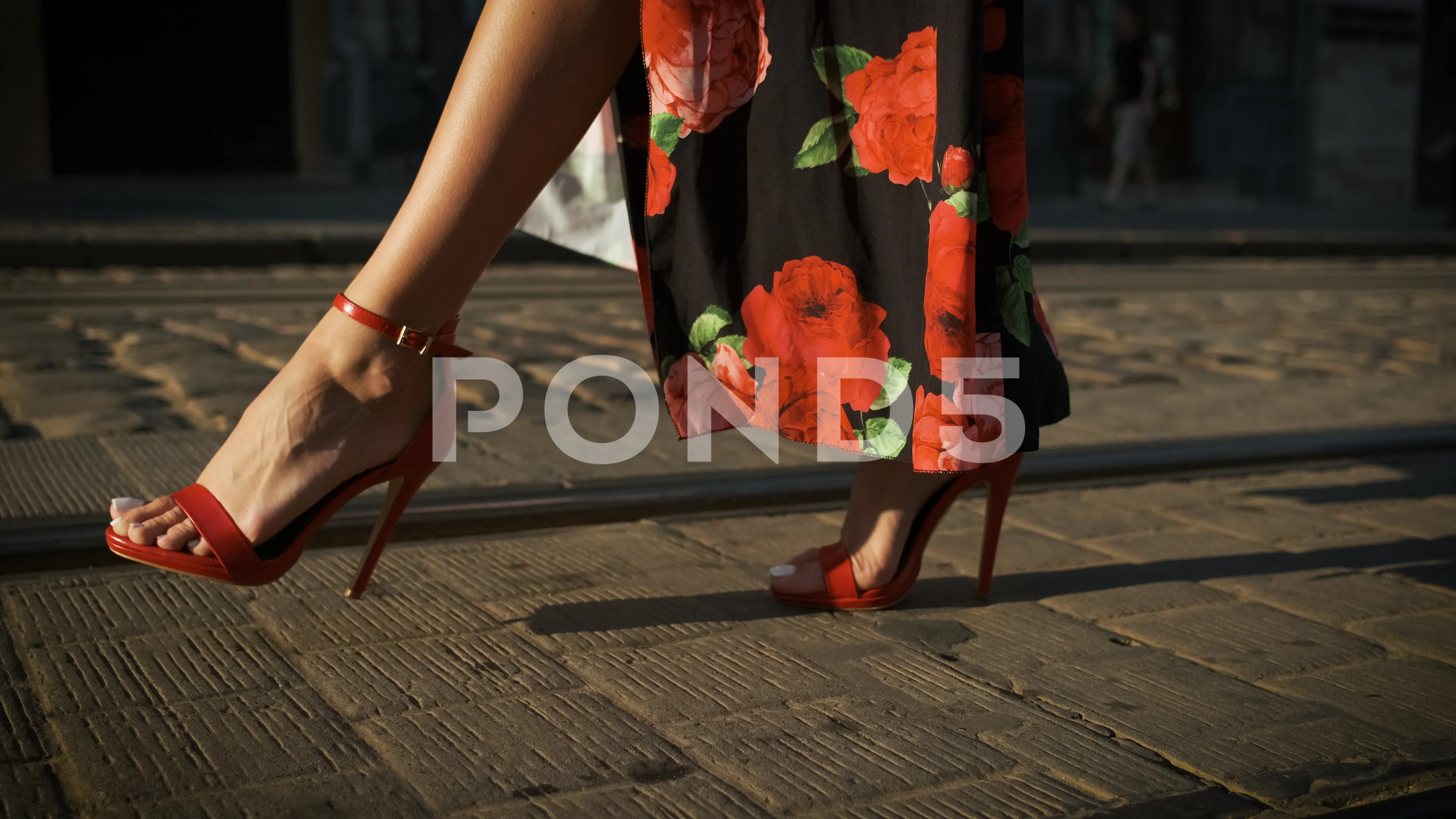 Beautiful long legs model walking around the city on heels in red shoes and  a