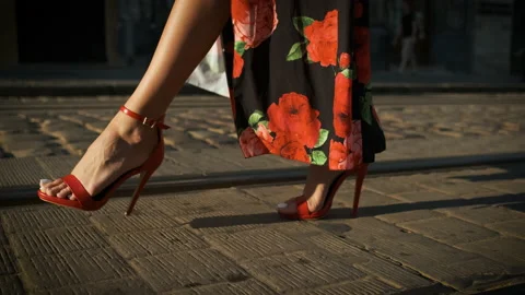 Beautiful long legs model walking around the city on heels in red shoes and a Stock Footage 137576344