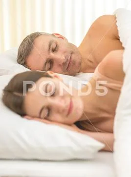 The beautiful lovers couple lay on the bed Stock Photos